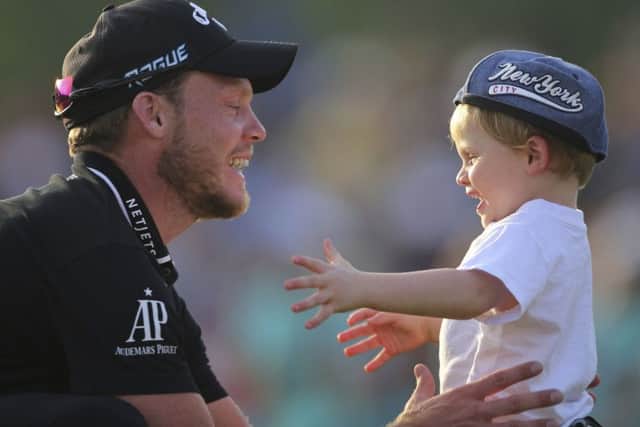 England's Danny Willett celebrates with his son after winning the DP World Tour Championship golf tournament in Dubai. Picture: AP/Kamran Jebreili