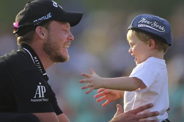 England's Danny Willett celebrates with his son after winning the DP World Tour Championship golf tournament in Dubai. Picture: AP/Kamran Jebreili)