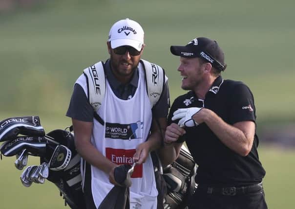 Danny Willett talks with his caddy as they approach the 18th green on Sunday at the DP World Tour Championship in Dubai. Picture: AP/Kamran Jebreili