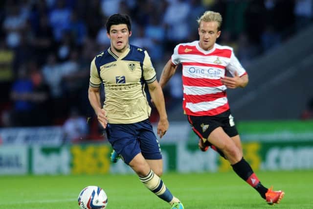 Alex Mowatt playing for Leeds United against Doncaster Rovers and James Coppinger.