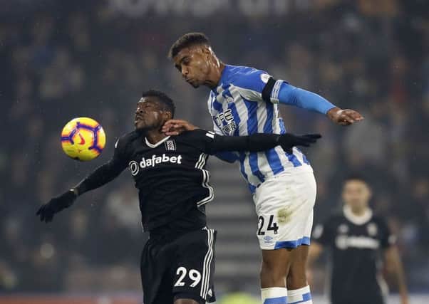 Huddersfield Town's Steve Mounie, right, engages in an aerial duel with Fulham's Andre-Frank Zambo Anguissa (Picture: Martin Rickett/PA Wire).