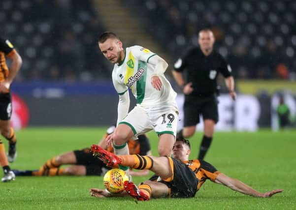 Norwich City's Tom Trybull (top) and Hull City's Reece Burke battle for the ball at the KCOM Stadium. Picture: Simon Cooper/PA