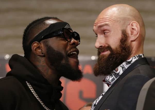 Boxers Deontay Wilder, left, and Tyson Fury exchange words as they face each other at a news conference in Los Angeles. (AP Photo/Damian Dovarganes)