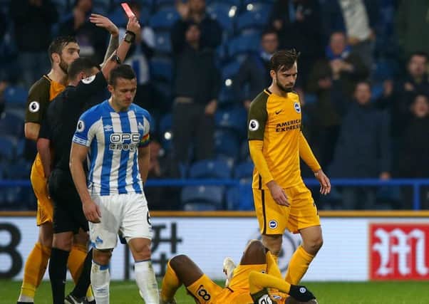 Huddersfield Town's Steve Mounie (not in picture) is shown a red card by referee Michael Oliver.