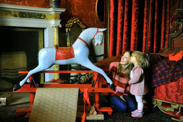 Daisy Dring, age two, and her mother Shelley, looking at a  Victorian rocking horse  at Temple Newsam House in Leeds.