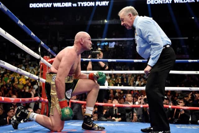 DOWN BUT NOT OUT: Tyson Fury takes a count during the WBC Heavyweight Championship bout with Deontay Wilder at the Staples Center in Los Angeles. Picture: Lionel Hahn/PA