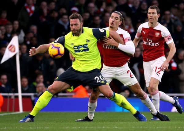 My ball: Huddersfield Town's Laurent Depoitre and Arsenal's Hector Bellerin battle for possession.