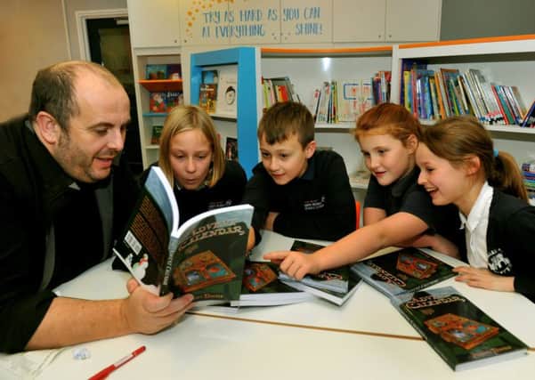 061218     Author Jeremy Davies  in the new library at South Milford Primary School  near Leeds  with  his latest book  Advent Calendar  and pupils  l to r  Lucy Prentice 9 , Kenny Wooffindin 10. Niamh Thompson 10 and Gracie Pinder10.