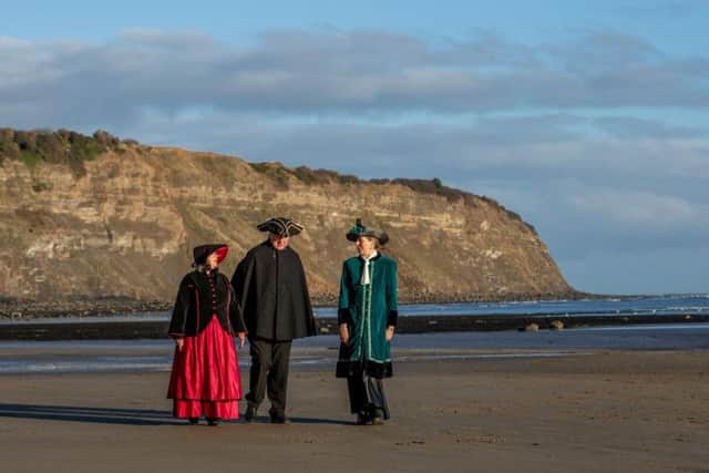 Pam Harrison, Kieth Harrison, dressed as a traditional town crier, and Suzanne Dekker on the beach. Picture: Charlotte Graham.