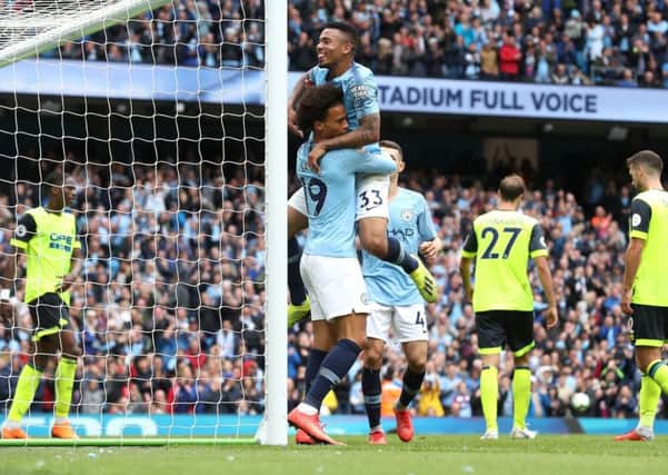 Manchester City's Leroy Sane (left) and Gabriel Jesus (right) celebrate after Huddersfield Town's Terence Kongolo scores an own goal.