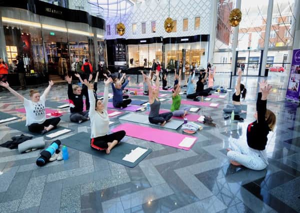 A yoga session in a shopping centre - but should classes be allowed in church halls?