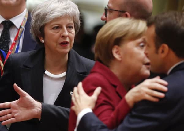 Theresa May arrives at last week's EU summit as Angela Merkel and Emmanuel Macron, the leaders of Germany and France, embrace.