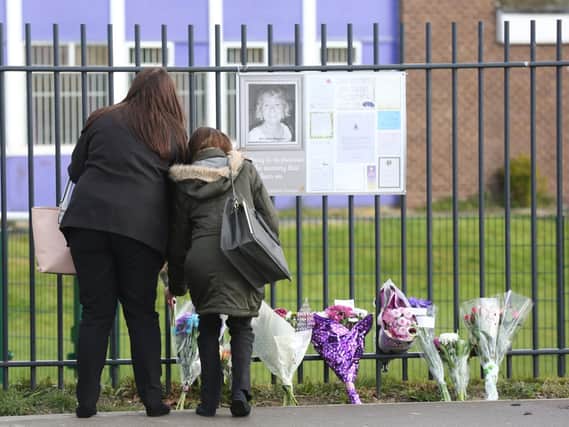 Mourners lay flowers in memory of teacher Ann Maguire, killed in 2014 at Corpus Christi Catholic College in Leeds. Photo: Ross Parry / SWNS Group.