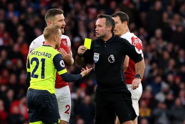 Referee Paul Tierney shows a yellow card to Huddersfield Town's Alex Pritchard during the Premier League match at the Emirates Stadium, London. (Picture: Isabel Infantes/PA Wire)