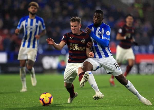 Newcastle United's Matt Ritchie (left) and Huddersfield Town's Isaac Mbenza (right) battle for the ball.