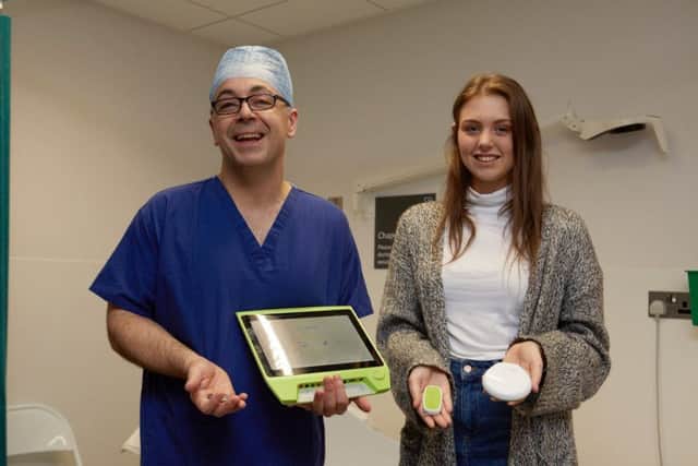 Surgeon Neil Harris with Amy Lyons and the device that has changed her life