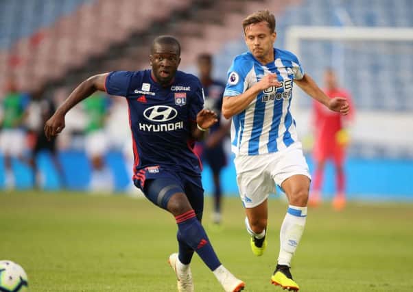 Huddersfield Town's Chris Lowe, right, seen battling with Lyon's Tanguy Ndombele in a pre-season friendly (Picture: Nigel French/PA Wire).