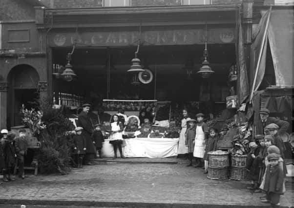 Children outside a greengrocers selling Christmas trees on Christmas Eve, 1918. (Picture credit: Getty Images).