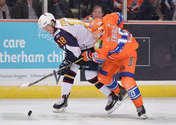 FAMILIAR FOES: Tanner Eberle battles for possession with Guildford's Brett Ferguson 
in Sheffield last month. the Flames won 6-5. 
Picture: Dean Woolley