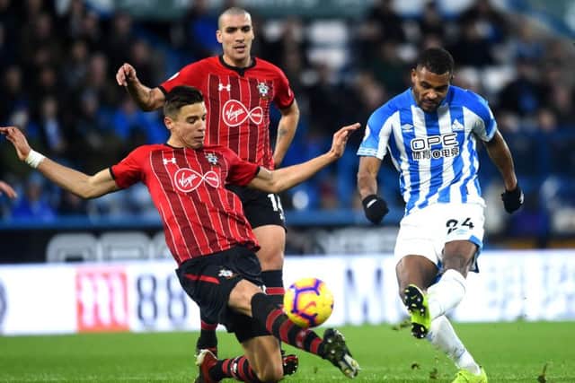 Huddersfield's Steve Mounie shoots under challenge from Jan Bednarek of Southampton. Picture: Nathan Stirk/Getty Images