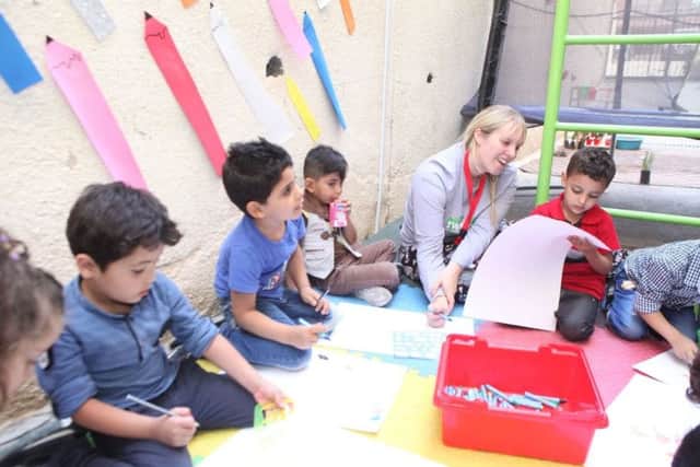 Helen Blanchard with a group of children learning through play in Jordan.
