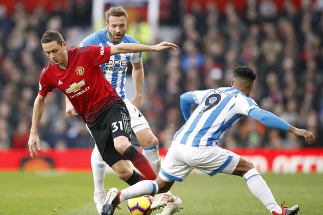 Manchester United's Nemanja Matic (left) and Huddersfield Town's Elias Kachunga battle for the ball (Pictures: PA).