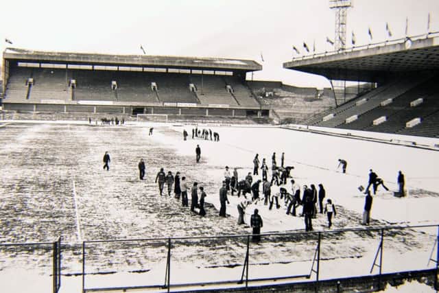 Preparing for a marathon: Volunteers clear the pitch of snow at Hillsborough on the morning of the first game which ended 1-1. Picture: Steve Ellis