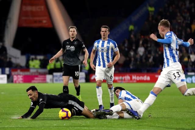 SEEING RED: Huddersfield Town's Christopher Schindler tackles Burnley's Dwight McNeil before being shown his second yellow card and being sent off. Picture: Martin Rickett/PA