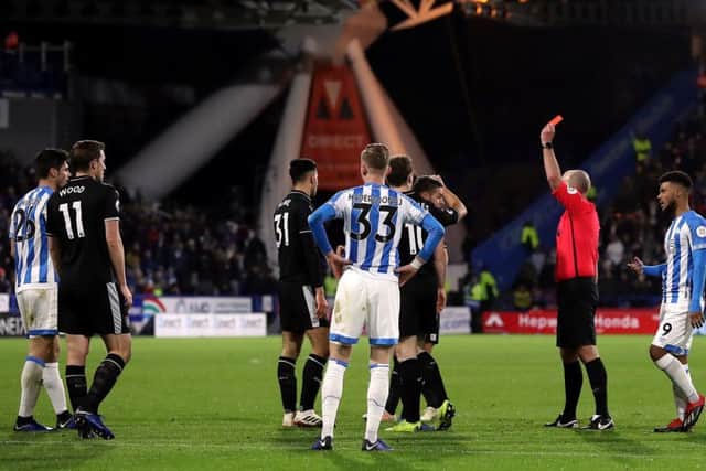 TURNING POINT: Huddersfield Town's Christopher Schindler (far left) is shown a red card by referee Mike Dean at the John Smith's Stadium. Picture: Martin Rickett/PA