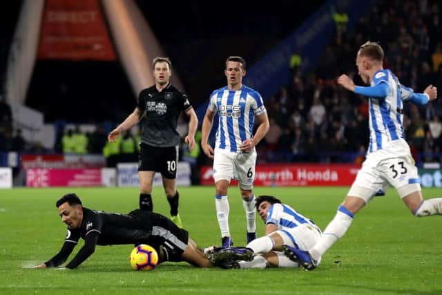 TURNING POINT: Huddersfield Town's Christopher Schindler tackles Burnley's Dwight McNeil before being shown his second yellow card and being sent off at the John Smith's Stadium. Picture: Martin Rickett/PA