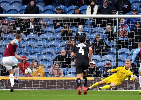Barnsley goalkeeper Adam Davies (second right) cannot save the penalty taken by Burnley's Chris Wood (left).