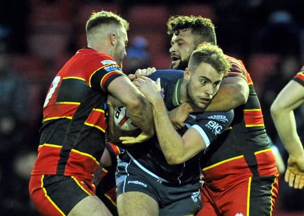 Dewsbury's Tom Garratt and Jordan Andrade combine to stop Featherstone Rovers's Daniel Waite-Pullan in their Yorkshire Cup clash. Picture Tony Johnson.