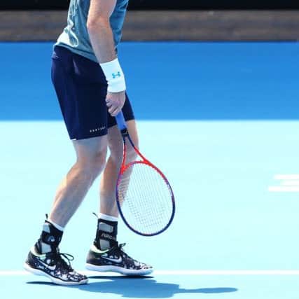 STRUGGLING: Andy Murray appears to be in discomfort in his practice match against Novak Djokovic of Serbia at Melbourne Park yesterday. Picture: Michael Dodge/Getty Images.