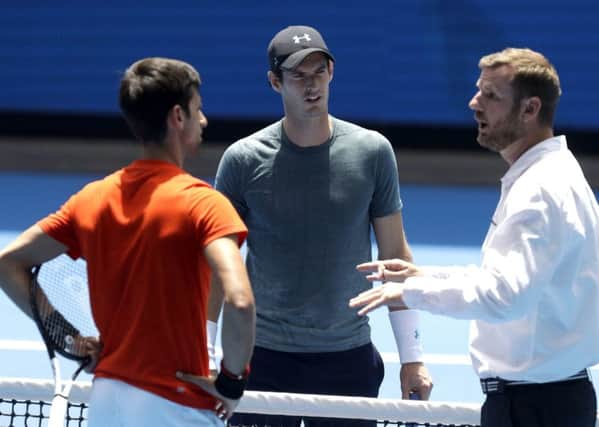 Match umpire Simon Canavan, right, talks with Andy Murray, and Serbia's Novak Djokovic ahead of their practice match at Melbourne Park. Picture: AP/Mark Baker