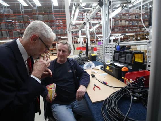 Jeremy Corbyn shares a packet of sweets with a factory workers in Wakefield