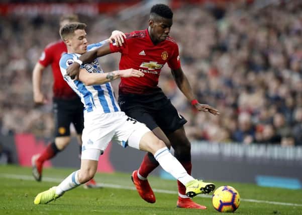 Battling: Huddersfield Town's Erik Durm challenges Manchester United's Paul Pogba.