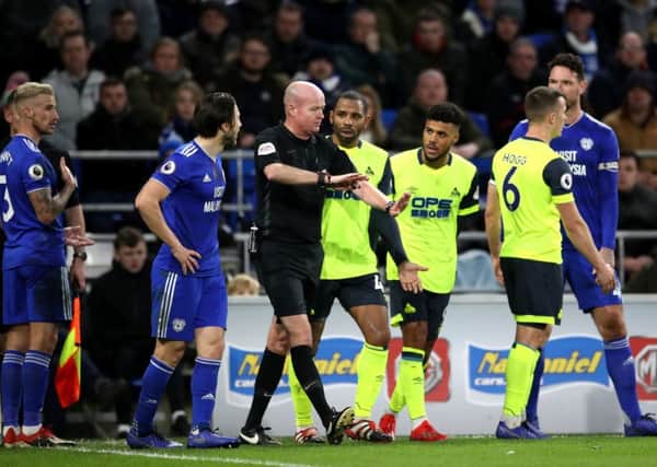 No penalty: Referee Lee Mason overturns his penalty decision to the disbelief of the Huddersfield players.