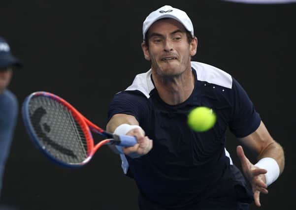 At full stretch: Britain's Andy Murray hits a forehand return in his first round match against Spain's Roberto Bautista Agut.