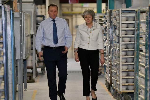 Theresa May hears from production manager Rob Fidler at a Stoke-on-Trent factory
