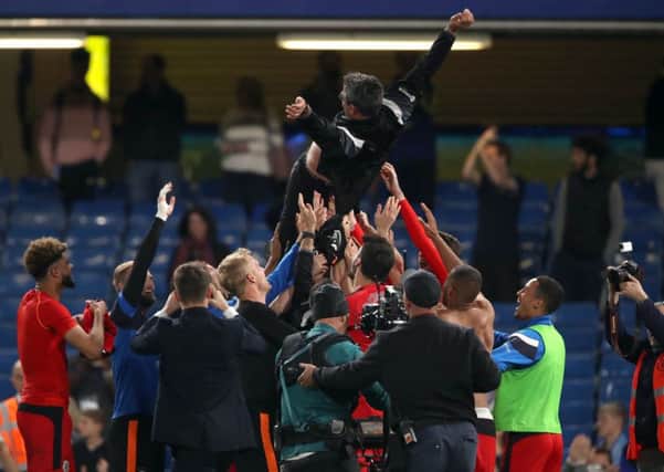 Huddersfield Town players lift manager David Wagner in the air as they celebrate after their 1-1 draw with hosts Chelsea at Stamford Bridge secured their Premier League safety Picture: John Walton/PA