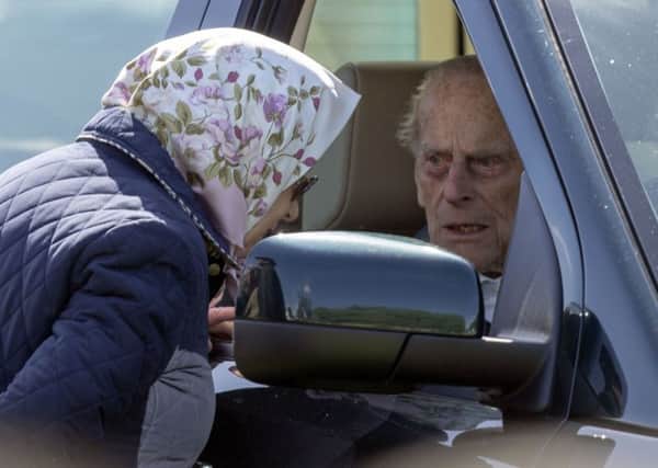 The Duke of Edinburgh at the wheel of a Land Rover car as he stops to talk to the Queen.