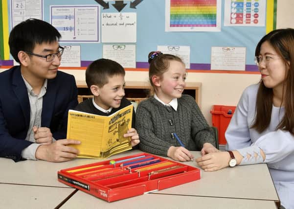 Shanghai teachers visit Northstead School in Scarborough . Teachers Lu Yong and Chen Jiajun do some class work with pupils Noah Simpson and Ruth Davis. pic Richard Ponter