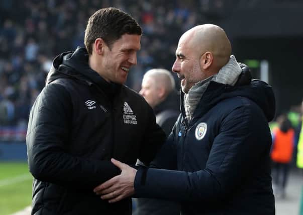 Huddersfield Town caretaker manager Mark Hudson, left, and Manchester City boss Pep Guardiola shake hands prior to kick off at the John Smith's Stadium (Picture: Martin Rickett/PA Wire).