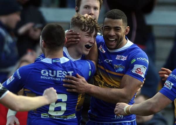 Leeds Rhinos captain Kallum Watkins, right, congratulates Harry Newman, centre, on his try against Castleford Tigers yesterday.