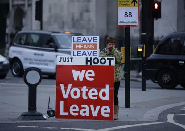 A pro-Brexit leave the European Union supporter demonstrates with placards outside the Houses of Parliament.