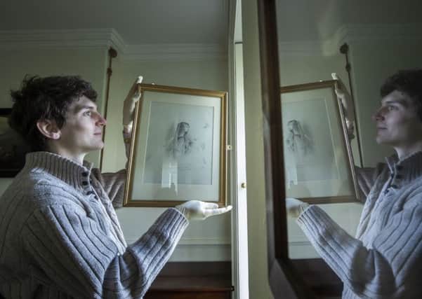 Pete Dilley holds a pencil drawing of Anne Bronte by Charlotte Bronte as he is reflected in a glass framed painting, as essential maintenance and conservation work is carried out at the Bronte Parsonage Museum in Haworth, West Yorkshire
