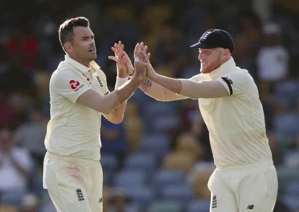 England's James Anderson, left, celebrates with team-mate Ben Stokes the dismissal of West Indies' Roston Chase during day one of the first cricket Test match at the Kensington Oval in Bridgetown, Barbados. (AP Photo/Ricardo Mazalan)