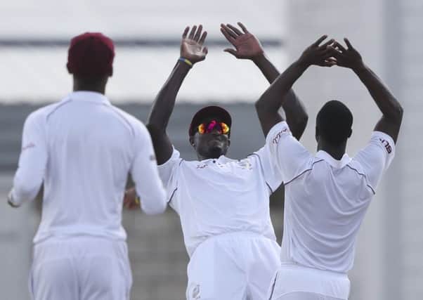 West Indies captain Jason Holder, centre, celebrates with team-mate Kemar Roach, right, following the dismissal of Englands Ben Foakes (Picture: Ricardo Mazalan/AP).