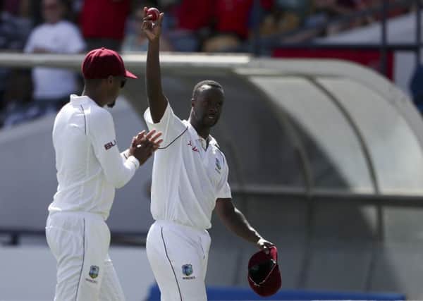 West Indies' Kemar Roach shows the ball after taking five wicket during day two of the first cricket Test match against England at the Kensington Oval in Bridgetown. (AP Photo/Ricardo Mazalan)