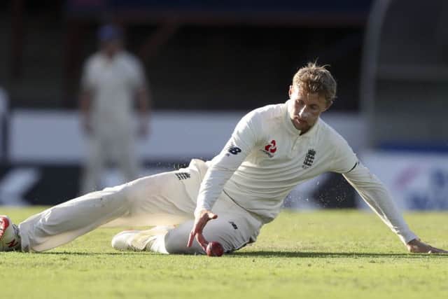 England's captain Joe Root fields a shot from his own bowling during day one of the first cricket Test match against West Indies at the Kensington Oval in Bridgetown, Barbados. (AP Photo/Ricardo Mazalan)